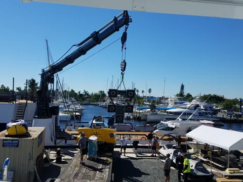Crane lifting machinery alongside a yacht