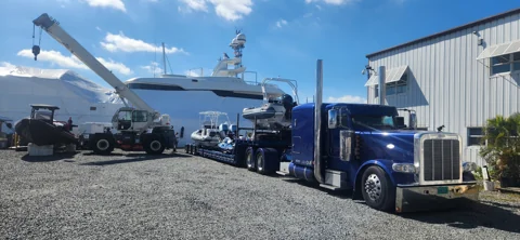 Boat transporter carrying tenders at the yard
