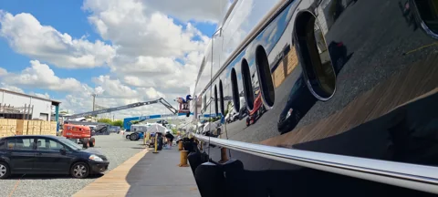 Extended man-lift access along a yacht hull for exterior polishing