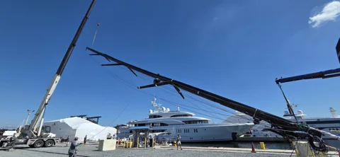 Crane supporting a mast horizontally at the yard