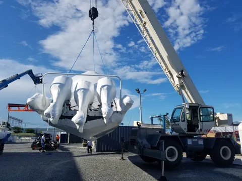 Crane handling a tender fitted with outboard engines