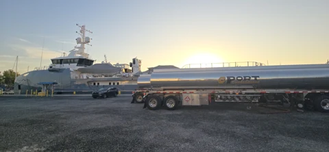 Dockside fuel tanker with yachts at sunset