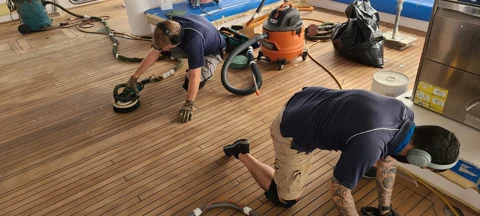Teak deck sanding and refinishing aboard a yacht