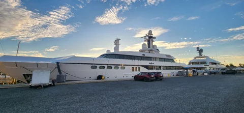 Yachts alongside the working yard beneath an evening sky