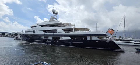 Dark-hulled motor yacht in a full dockside profile
