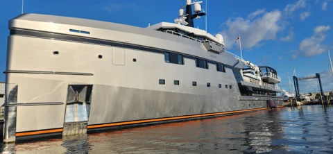Silver-hulled yacht alongside the dock